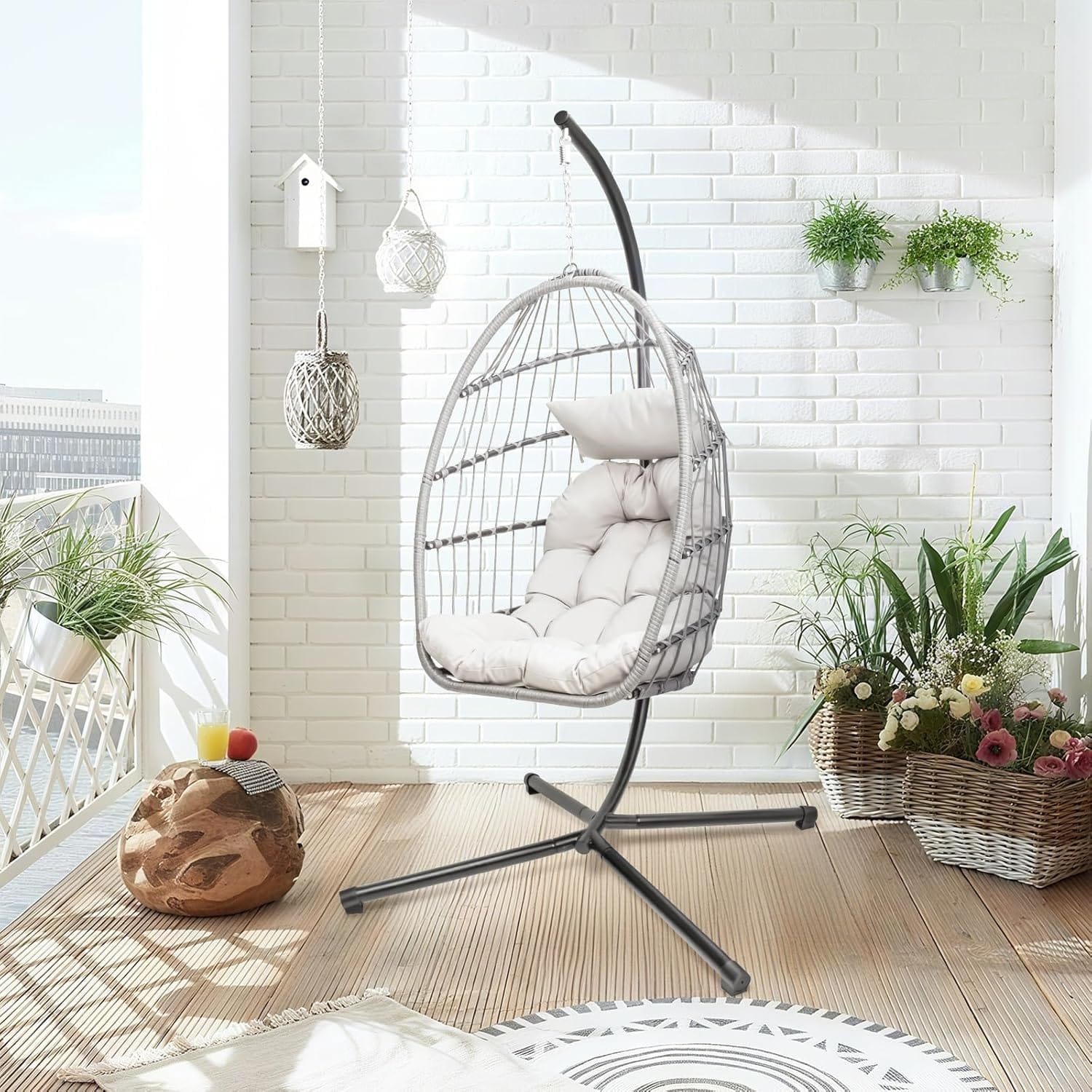Single hanging egg chair with stand in a bright leisure space